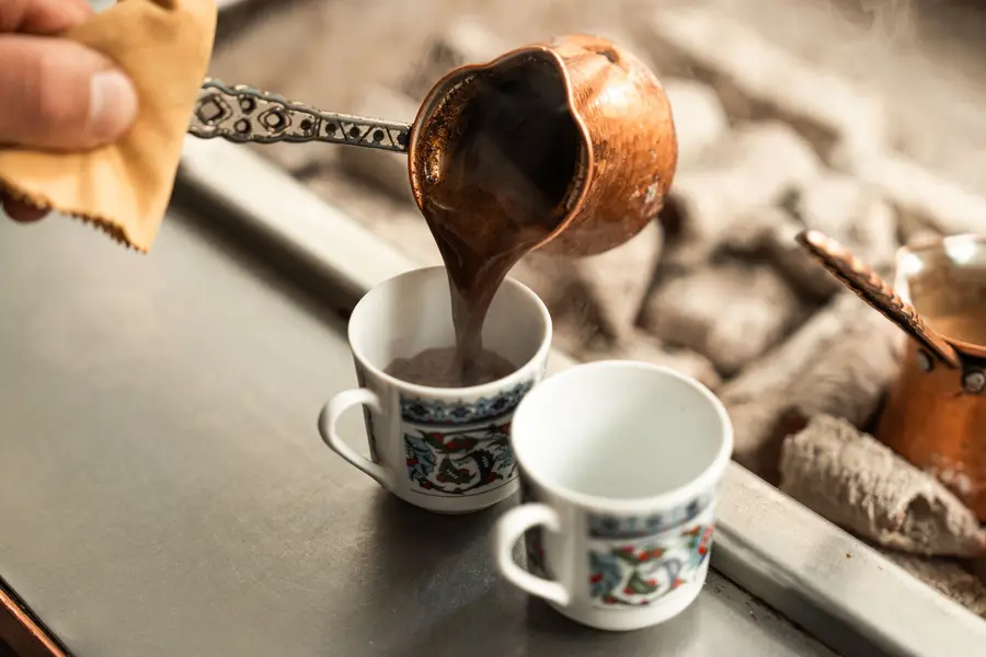 Кофе разливают в узорные чашки
